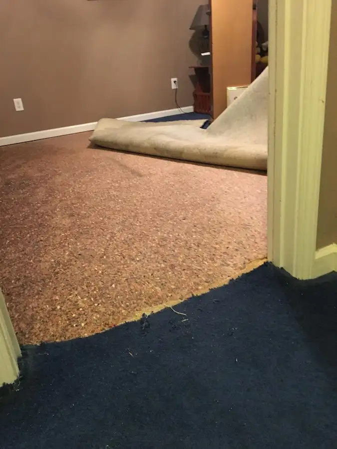 Carpet pad removal revealing water damage during Water Mitigation Services in Omaha